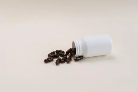 Lying White Bottle, Container With Scattered Brown Sunflower Lecithin Softgel Stock Photos