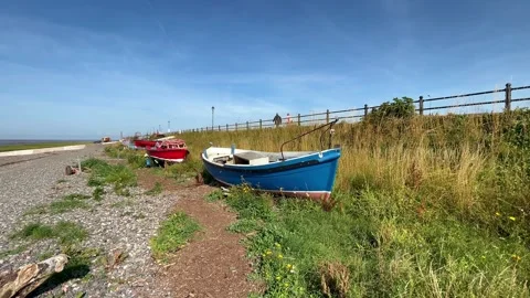 Lytham Saint Annes, UK 28 July, 2024; Abandoned boats on pebble beach shoreline Stock Footage 280384545