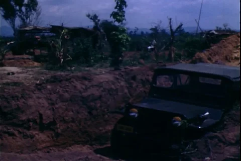 A M-151 jeep parked in protective ditch and soldiers in mortar emplacement-1972 Stock Footage 106060704