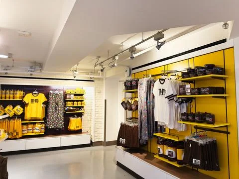 M and M themed candy shop interior with branded merchandise and bright yell.. Stock Photos