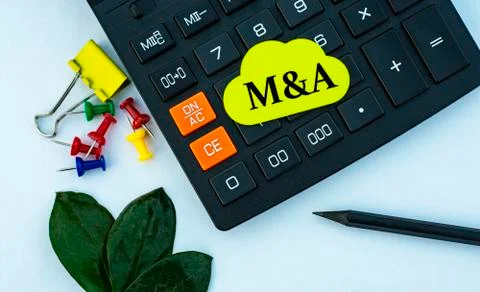 M&amp;A - word on yellow note sheet on white background with calculator, pencil, Stock Photos