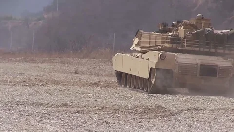 M1 Abrams tank driving on sandy terrain Stock Footage 106679529