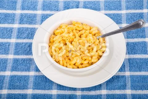 Mac and cheese in white bowl on blue towel Stock Photos