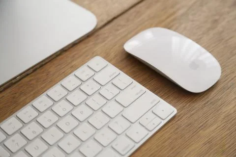 Mac keyboard and magic mouse on wooden table Stock Photos
