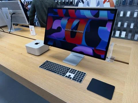 Mac Studio computer setup on a wooden desk with keyboard and mousepad in a .. Stock Photos