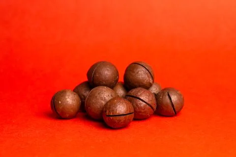 Macadamia nut on a red background. delicious and healthy nut Stock Photos
