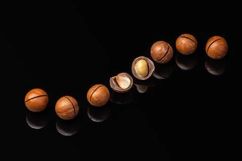 Macadamia nuts on a black mirror background Stock Photos