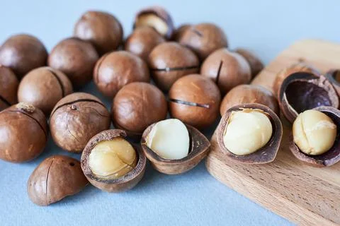Macadamia nuts on a blue background. Macadamia nuts in close-up. Stock Photos
