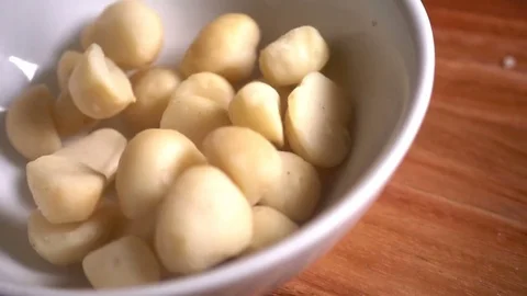 Macadamia nuts falling into bowl in slow motion Stock Footage 76437705