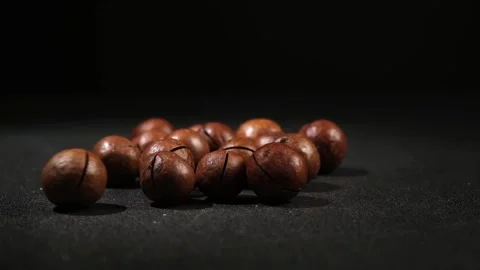 Macadamia nuts with a key on black background. Stock Footage 239825551
