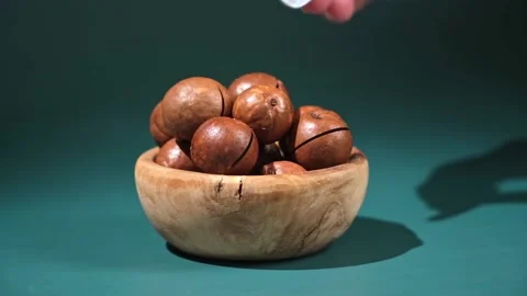 Macadamia nuts with a key on turquoise background Stock Footage 239852008