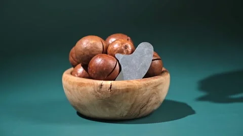 Macadamia nuts with a key on turquoise background Stock Footage 241424024