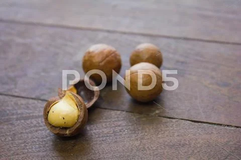 Macadamia nuts on wood background Stock Photos