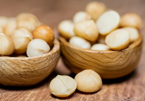 Macadamia nuts in on wood table Stock Photos