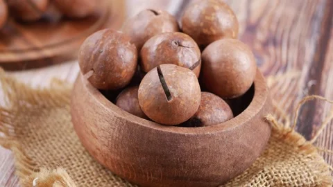 Macadamia Nuts in a Wooden Bowl on a Rustic Table Stock Footage 341542479