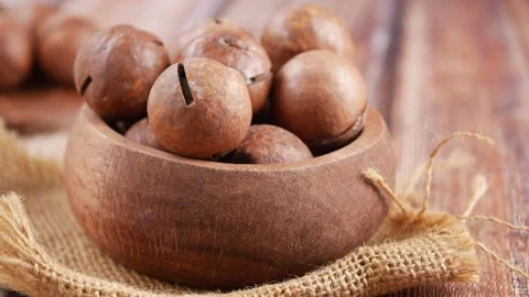 Macadamia nuts in wooden bowl on table Stock Footage 337982204