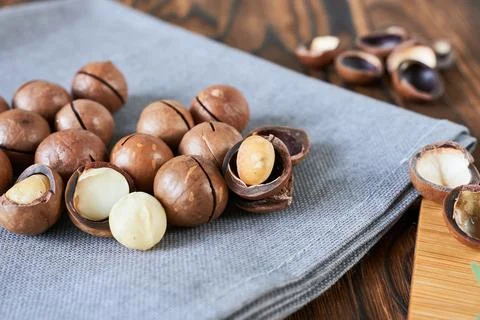 Macadamia nuts on a wooden table. Macadamia is a superfood. Stock Photos