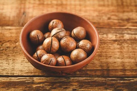 Macadamia nuts on wooden table Stock Photos