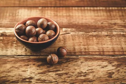 Macadamia nuts on wooden table Stock Photos