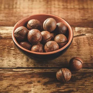 Macadamia nuts on wooden table Stock Photos