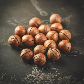 Macadamia nuts on wooden table Stock Photos