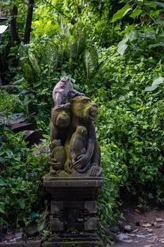 Macaque on Monkey Sculpture in Ubud Monkey Forest Stock Photos