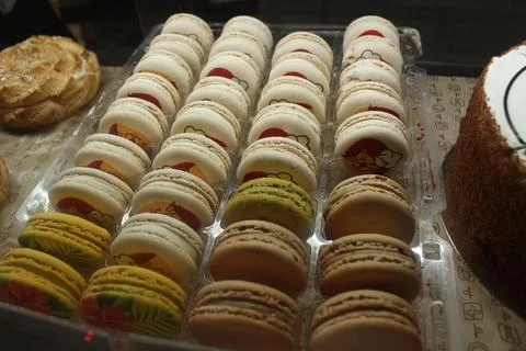Macaron cake rows in the window of the store's cafe. Traditional desserts Stock Photos