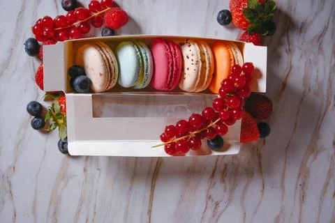 Macaron dessert, a box with colorful macarons lies on a marble style. Sweet.. Stock Photos