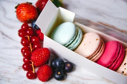 Macaron dessert, a box with colorful macarons lies on a marble style. Sweet.. Stock Photos