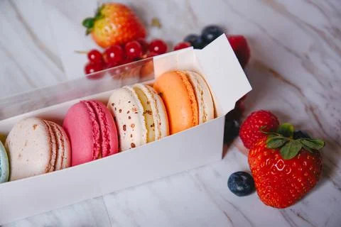 Macaron dessert, a box with colorful macarons lies on a marble style. Sweet.. Stock Photos