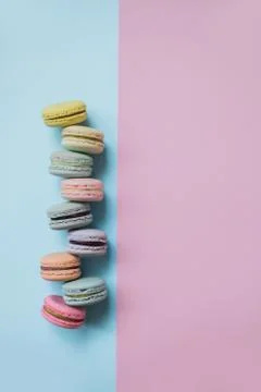 Macaron or macaroon biscuits on pastel blue and pink background top view. Stock Photos