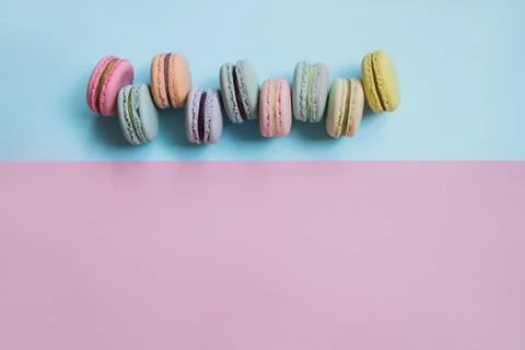 Macaron or macaroon biscuits on pastel blue and pink background. Copy space. Stock Photos