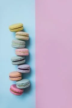 Macaron or macaroon biscuits on pastel pink and blue background. Copy space. Stock Photos