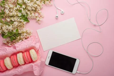 Macaroni in a box on a light pink background with white flowers, telephone, c Stock Photos