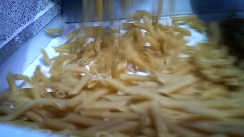 Macaroni falling down in a la carte machine on a conveyor belt Stock Footage 154370538