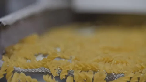 Macaroni falling down in a la carte machine on a conveyor belt Stock Footage 162480422
