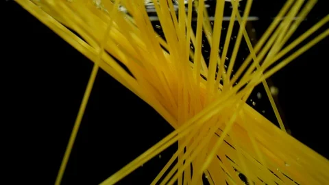 Macaroni pasta splash falling into boiled water on black background Stock Footage 113594376