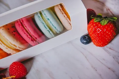 Macaronis in a white box with a transparent window. Color dessert, pink, mi.. Stock Photos