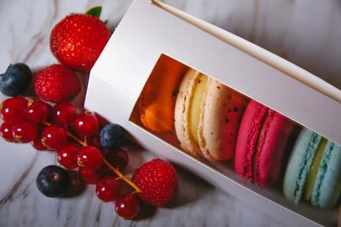 Macaronis in a white box with a transparent window. Color dessert, pink, mi.. Stock Photos
