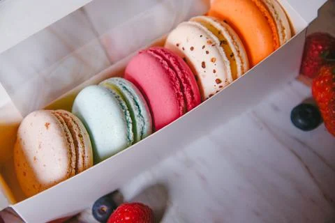 Macaronis in a white box with a transparent window. Color dessert, pink, mi.. Stock Photos