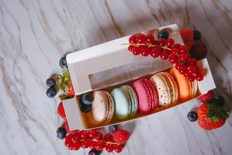 Macaronis in a white box with a transparent window. Color dessert, pink, mi.. Stock Photos