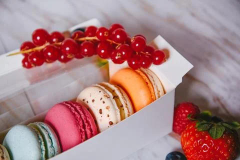 Macaronis in a white box with a transparent window. Color dessert, pink, mi.. Stock Photos