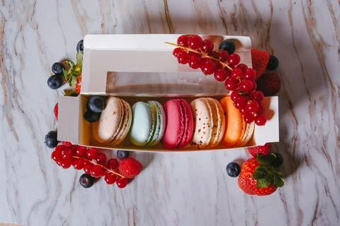 Macaronis in a white box with a transparent window. Color dessert, pink, mi.. Stock Photos