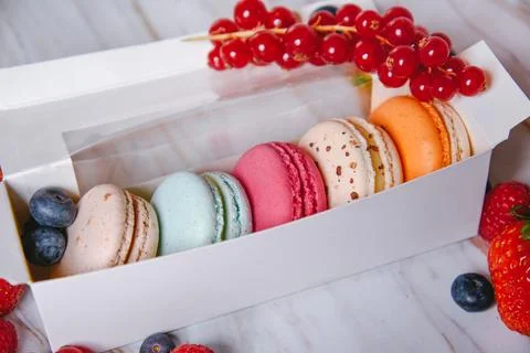 Macaronis in a white box with a transparent window. Color dessert, pink, mi.. Stock Photos