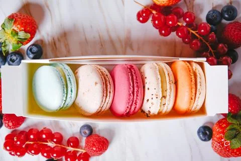 Macaronis in a white box with a transparent window. Color dessert, pink, mi.. Stock Photos