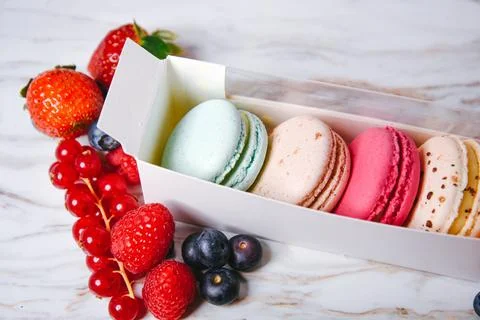 Macaronis in a white box with a transparent window. Color dessert, pink, mi.. Stock Photos