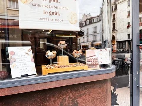 Macarons and chocolates displayed in a Paris bakery window with street refl.. Foto stock