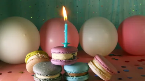 Macarons and one candle on blue and pink background with decorations Stock Footage 236128463
