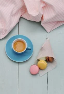 Macarons in backing paper cornet and blue espresso cup Stock Photos
