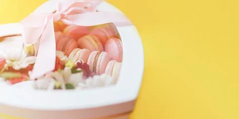 Macarons with different types of flowers in a box in the shape of a heart Stock Photos